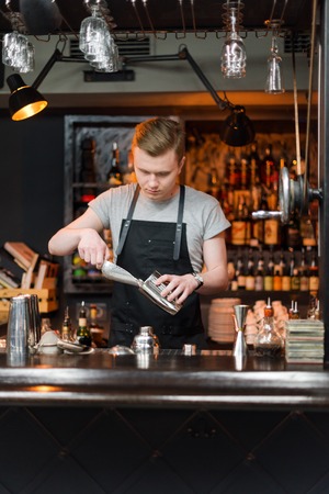 KIEV, UKRAINE - 30 OCTOBER, 2016: Barman festival. Young handsome bartender is making cocktail.