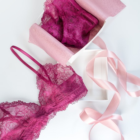 Shopping and fashion, female wardrobe concept. Set of glamorous stylish sexy lace lingerie in pink giftbox on white background. Woman accessories.の写真素材