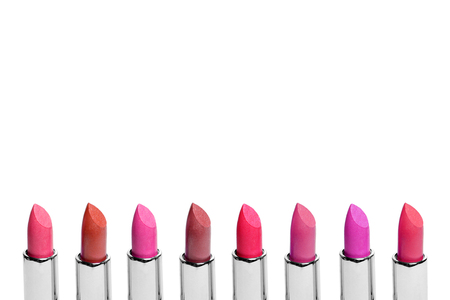 Set of color lipsticks arranged in line isolated on white background. A row of red, pink and wine lipstick with free space for textの写真素材