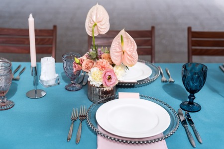 Flower table decorations for holidays and wedding dinner. Table set for holiday, event, party or wedding reception in outdoor restaurant.の写真素材