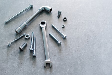 Construction tools. The screws, nuts and bolts on concrete background. Repair, home improvement concept. Space for text, top view, flat lay.の写真素材