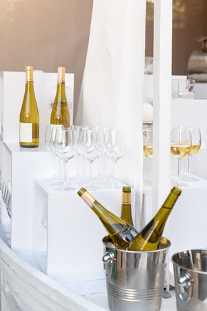 Bottles of white wine standing on serving table. Outdoor party, catering service.の写真素材