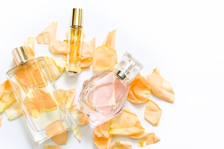 Perfume bottles with flower petals on light background. Perfumery, fragrance collection. Women...
