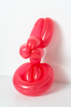 Simple red twisted balloon animal rabbit on white. Toy of balloons, bunny. Balloon art.の写真素材