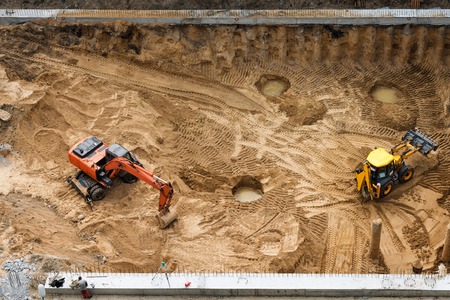Construction of concrete foundation of new building. Construction machinery, excavators, top viewの写真素材