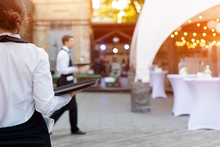 Waiter holding an empty tray in outdoor cafe. Catering service.の写真素材