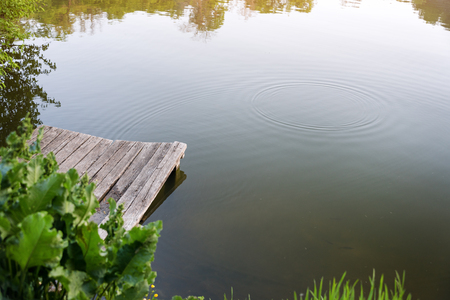 Old wooden pier on a lake at sunny summer day.の写真素材