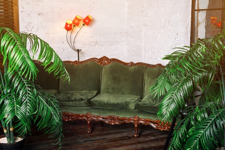 Woman drinking wine. Beautiful young blonde woman in long golden evening dress with glass of red wine in luxury loft interior.の写真素材