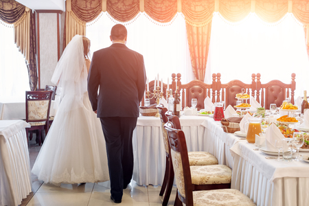 Bride and groom in restaurant. Wedding table at a wedding feast, dinner and party.の写真素材