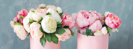 Flowers in round luxury present boxes. Bouquet of pink and white peonies in paper box. Mock-up of hat box of flowers with free copyspace for text. Interior decoration in in pastel colors.の写真素材