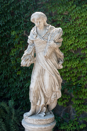 Old marble statue, man with sheafs of wheat in the park.の写真素材