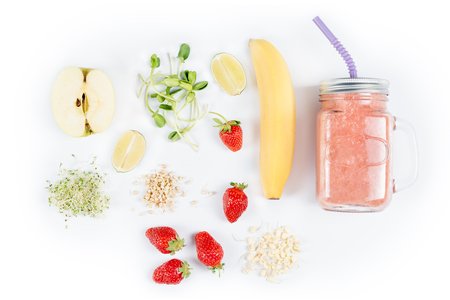 Detox cleanse drink, fruits and berries smoothie ingredients. Natural, organic healthy juice for weight loss diet or fasting day. Mason jar of dietary drink with strawberries, microgreens and bananaの写真素材