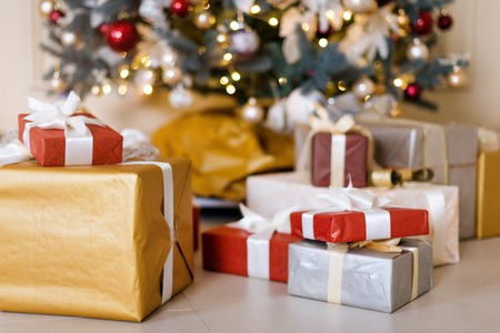 Beautiful holdiay decorated room with Christmas tree with presents under it. New Year decorations.の写真素材