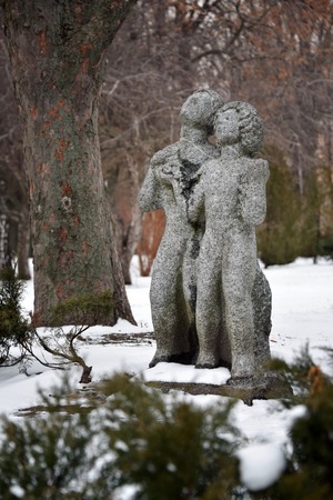 Sculptures of lovers, man and woman in winter park, Kyiv, Ukraine. Couple sculpture standing in the garden in the mood of love together in valentine's dayの写真素材