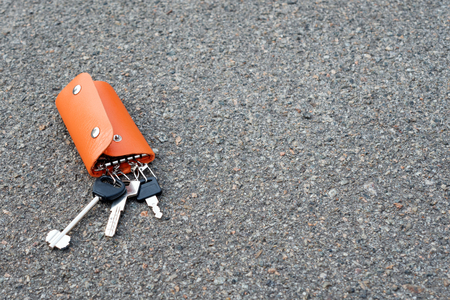 A bunch of keys in a leather case lying on the ground. Keys in the leather partholme were lost or foundの写真素材