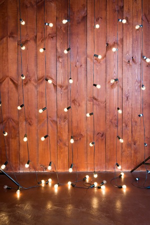 Light bulbs on wooden background. Vintage edison light bulbs garland in loft interior