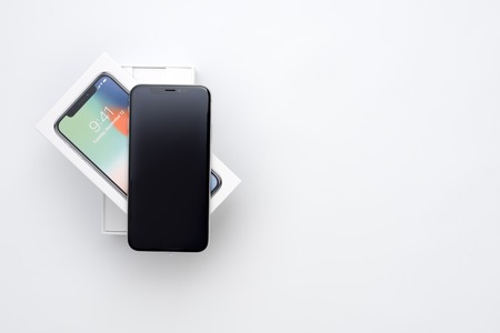 KYIV, UKRAINE - 26 JANUARY, 2018: New Iphone X smartphone model close up. Newest Apple Iphone 10 mobile phone device on white branded Apple box on white table in store.のeditorial素材