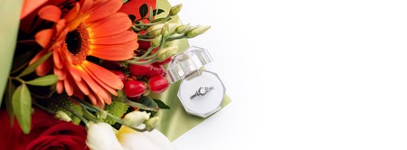 Engagement ring in a gift box with bright bouquet of flowers. The offer to get married. Gift for St....