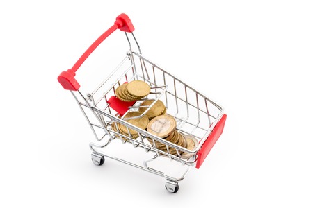Shopping cart with euro coins in it on white background. Supermarket shopping, sale and cash back theme. Copyspace for text.の写真素材