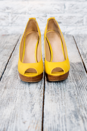 Pair of woman shoes on a wooden floor with free space for text. High heels, shopping and sale themeの写真素材