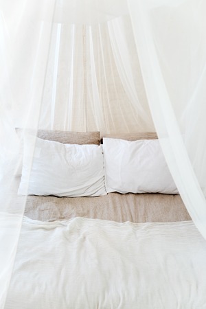 Four-poster bed with two pillows. Scandinavian simplicity design. Eco loft apartmentsの写真素材