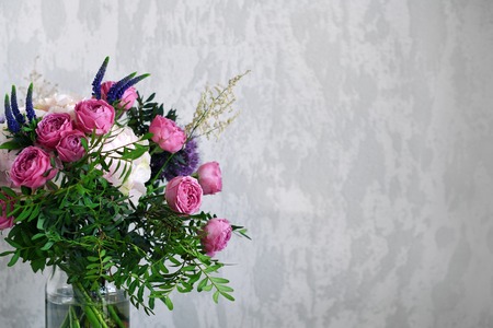 Flowers in a glass jar on grey concrete background. Vintage home decor. Copy space for textの写真素材