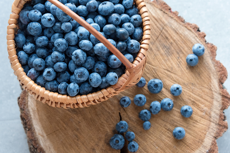 Blueberry in basket on wooden table background. Ripe and juicy fresh picked blueberries closeup, top view.の写真素材