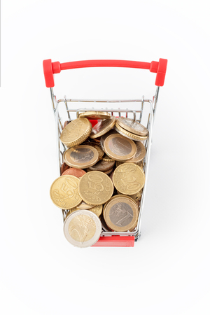Shopping cart with euro coins in it on white background. Supermarket shopping, sale and cash back theme. Copyspace for textの写真素材