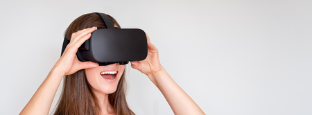 Smiling positive woman wearing virtual reality goggles headset, vr box. Connection, technology, new...