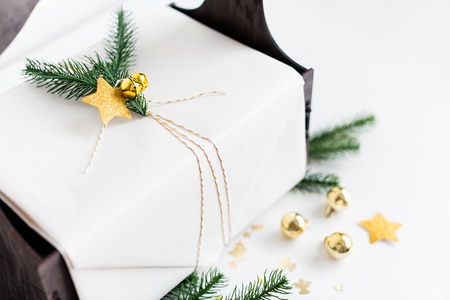 Luxury New Year gift with gold decoration and tree branches. Christmas gift in wooden basket....