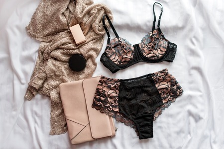 Set of glamorous stylish sexy lace lingerie with woman accessories on white bedsheets background. Shopping and fashion concept.の写真素材