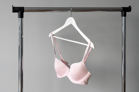 Pink bra hanging on a hanger. Textile, Underwear. Female bra in lingerie underwear store. Advertise, sale, fashion concept.の写真素材