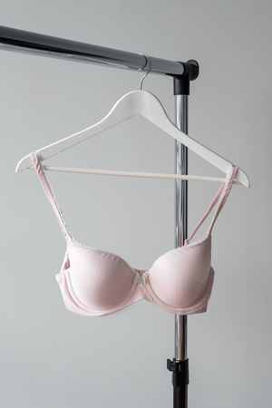 Pink bra hanging on a hanger. Textile, Underwear. Female bra in lingerie underwear store. Advertise, sale, fashion concept.の写真素材