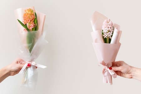 Woman hands with manicure holding spring flowers. Fresh bouquets with hyacinth. Copyspace for text. Love and gift concept.の写真素材