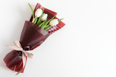 Spring flowers. Fresh tulips bouquet in minimal style on light background. Top view, spring flat lay with copyspace for text. Love and gift conceptの写真素材