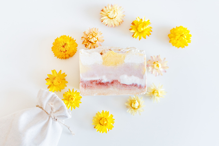 Natural hand made soap with dry yellow flowers on light background spa settingの写真素材