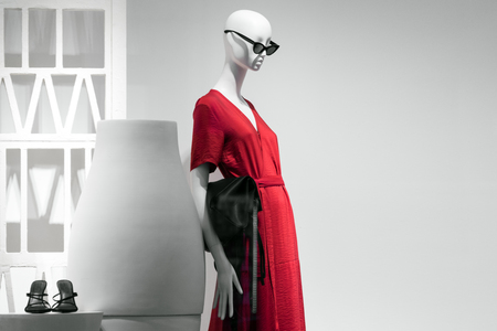 Female mannequin portrait in sunglasses and red dress. Sale and advertising theme. Copyspace for textの写真素材