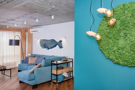 Minimalist modern living room with sofa in loft style flat. Modern loft studio with a kitchen and living room, open space interior in Scandinavian style with furniture. Real photoの写真素材