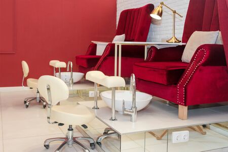 Chairs in a pedicure beauty salon. Interior of empty modern nail salon. Work places for masters of manicure. Pedicure cabinetの写真素材