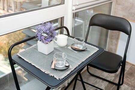 Empty coffee cups on the balcony with sunlight in the morning. Breakfast preparations. Hotel or...