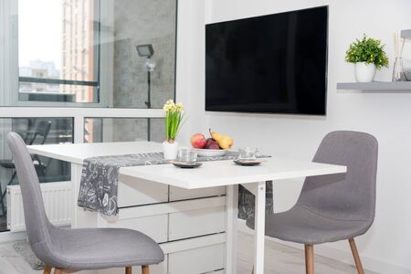 Coffee cups and fruits for breakfast. Morning table with espresso, fruits and flowers on a white wooden table in the kitchen.の写真素材