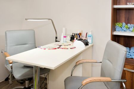 Interior of empty modern nail and beauty salon. Table with lamp, manicure interior business.の写真素材