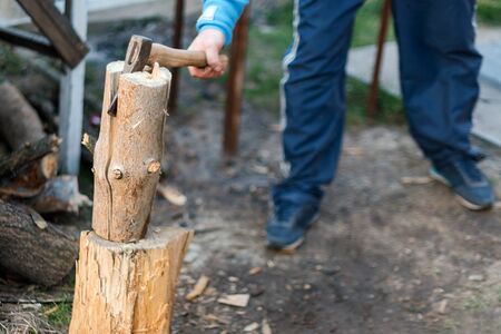 Man chopping wood in the backyard. Lumberjack cuts logs.の写真素材