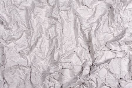Crumpled gray paper texture. Wrinkled paper background with cracks and kinks