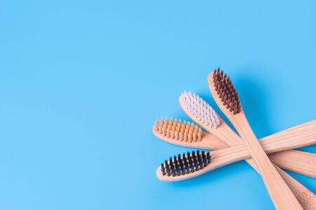 Bamboo toothbrushes on blue background. Eco friendly daily oral hygiene, teeth care and health....