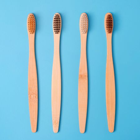 Bamboo toothbrushes on blue background. Eco friendly daily oral hygiene, teeth care and health....