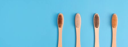 Bamboo toothbrushes on blue background. Eco friendly daily oral hygiene, teeth care and health....