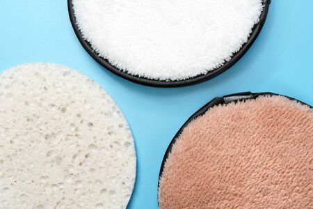 Three different facial puffs on blue background. Beauty, skin, hair or body care conceptの写真素材