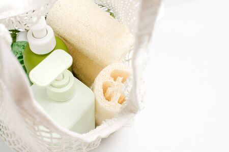 Green container for shampoo, conditioner or liquid soap in eco bag. Loofah or luffa washcloth,...