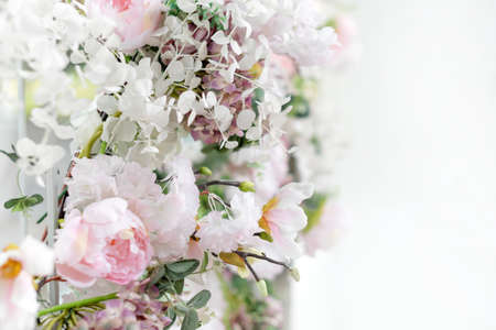 Flower wall, wedding backdrop, floral hand made decoration. Light background of artifical flowers. Vertical garden with peonies and hydrangeas. Elegant arrangement floristics setting. Copyspaceの写真素材